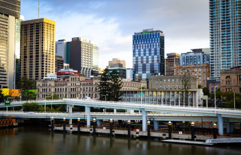Brisbane riverfront with modern skyscrapers and historic stone facades