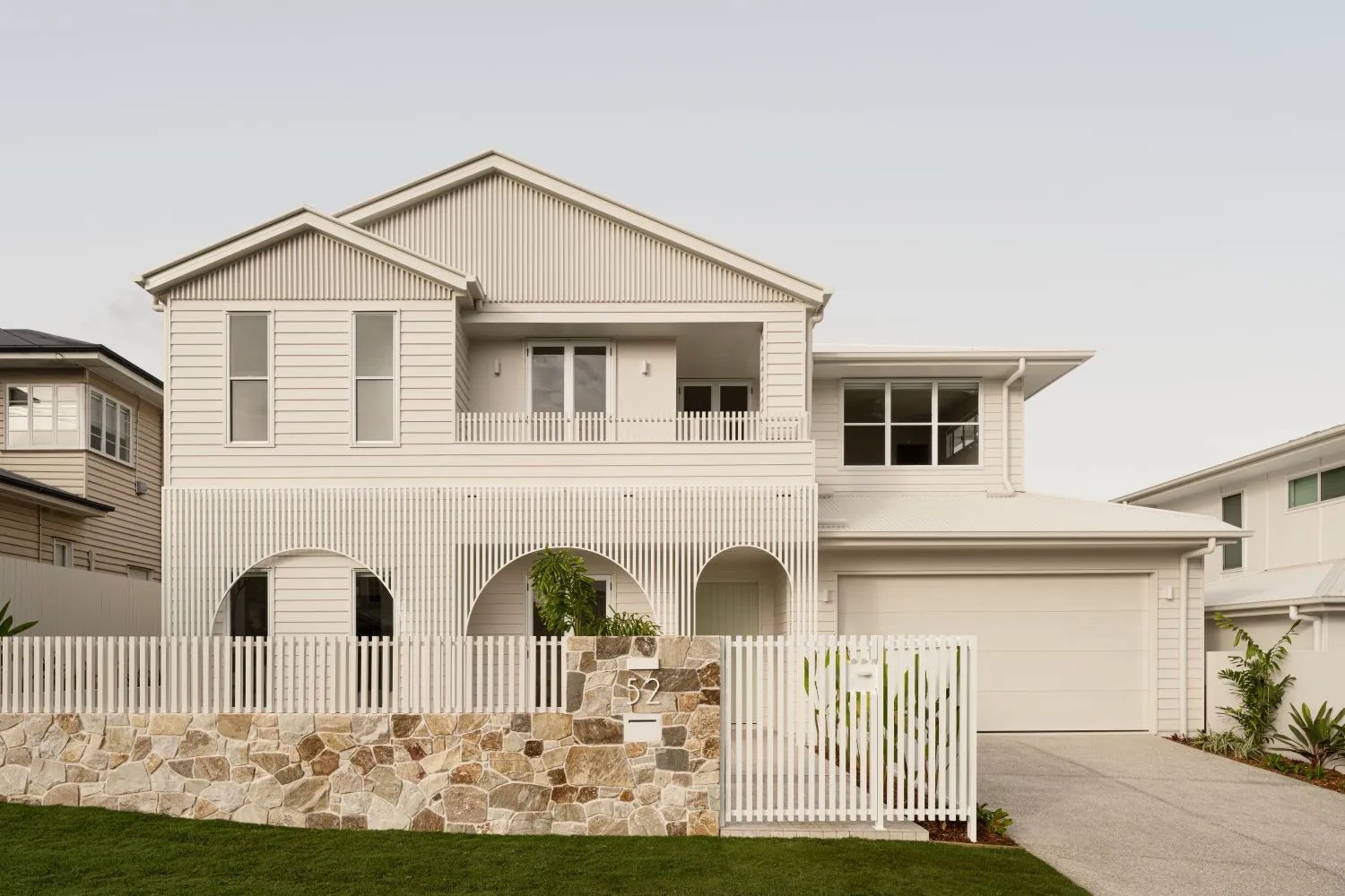 Contemporary two‑storey Brisbane house with lawn and picket fence